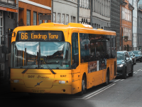 guld bus i bybillede med sort skygge i hjørnet der illustrerer grå stær